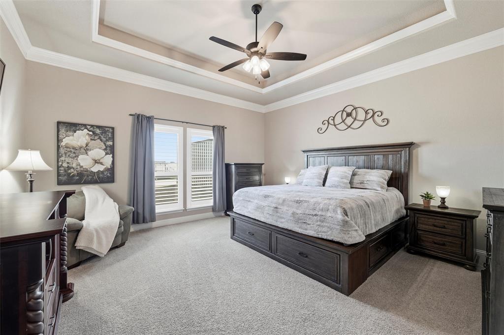 121 Bluff Ridge Court Paradise, TX 76073 - Photo 13 of 33 Bedroom with light colored carpet, a ceiling fan, ornamental molding, and a raised ceiling