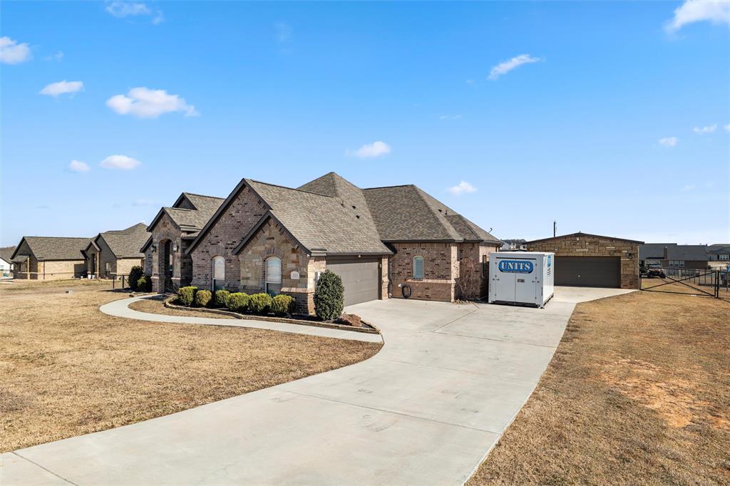 121 Bluff Ridge Court Paradise, TX 76073 - Photo 2 of 33 French country style house with brick siding, a residential view, driveway, and roof with shingles