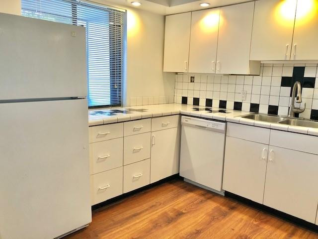 310 Racquet Club Road, Unit 203 Weston, FL 33326 - Photo 4 of 14 a kitchen with stainless steel appliances granite countertop a sink a stove and white cabinets with wooden floor