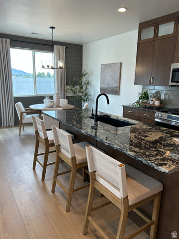 2011 West 1150 South, Unit 1042 Payson, UT 84651 - Photo 13 of 39 Photos are of model home.Kitchen island featuring a black granite countertop and a built-in sink with a matte black faucet