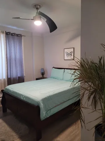 a bedroom with a bed and a potted plant