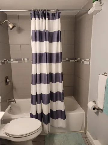 a white toilet sitting next to a bathroom sink and a shower