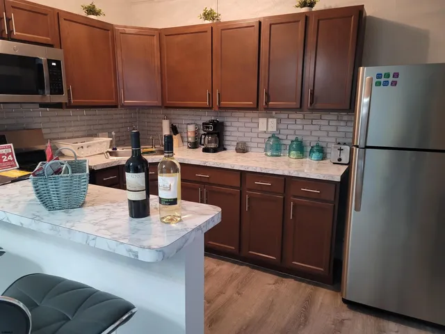 a kitchen with stainless steel appliances granite countertop a sink a refrigerator and a stove