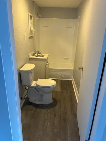 a bathroom with a sink a toilet a mirror and shower