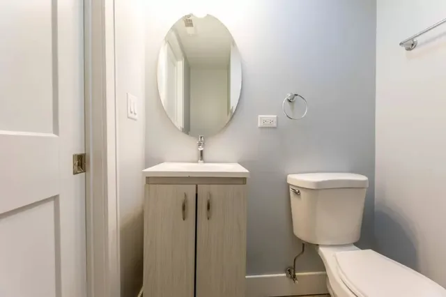 a bathroom with a toilet a sink and mirror