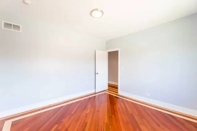 a view of a room with wooden floor and white walls