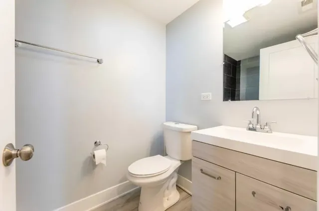 a bathroom with a toilet sink and mirror