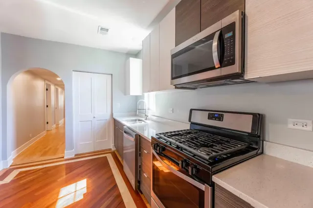 a kitchen with stainless steel appliances granite countertop a stove and a microwave