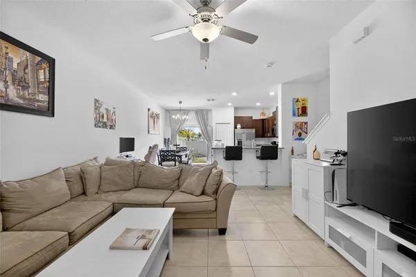 a kitchen with stainless steel appliances granite countertop a stove a refrigerator a kitchen island a dining table and chairs with wooden floor