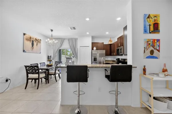 a kitchen with a sink dining table and chairs
