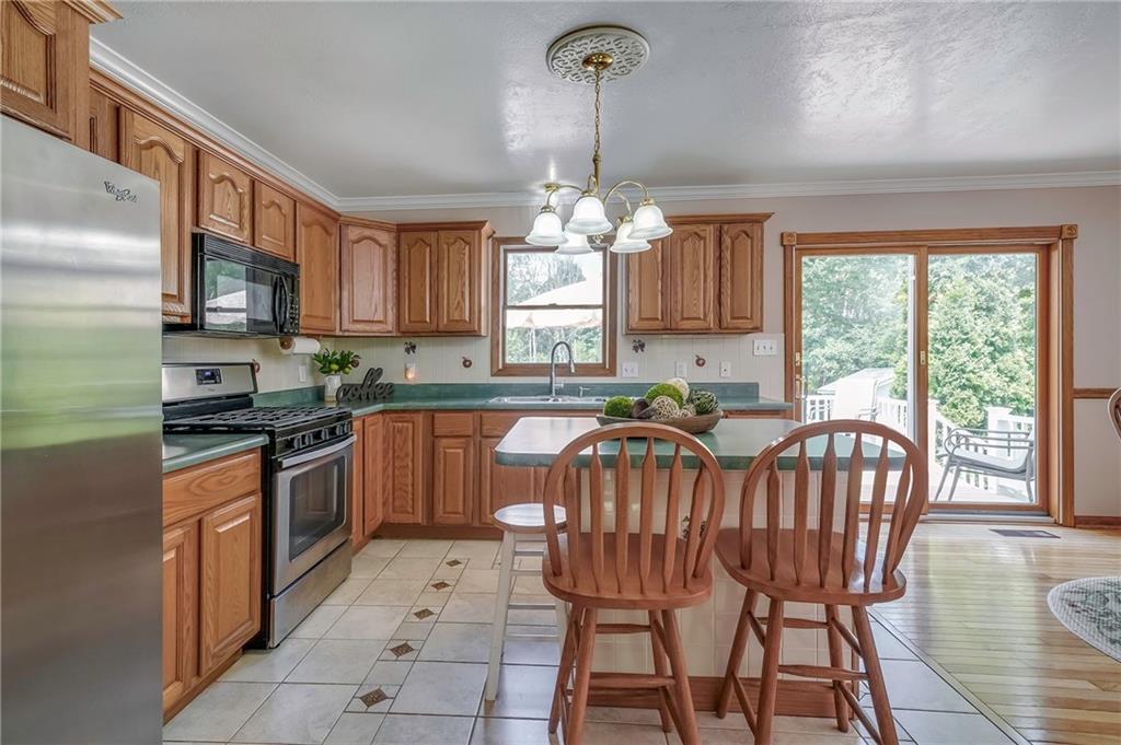 563 Leeper Road Georgetown, PA 15043 - Photo 6 of 25 Gorgeous ceramic tile floors, SS fridge and stove, and center island complete this well maintained kitchen.