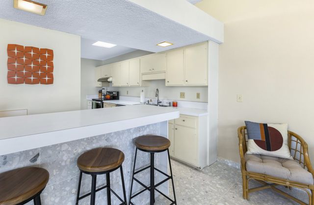 a kitchen with a dining table chairs and a refrigerator