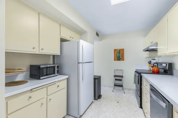 a kitchen with stainless steel appliances a refrigerator sink and cabinets