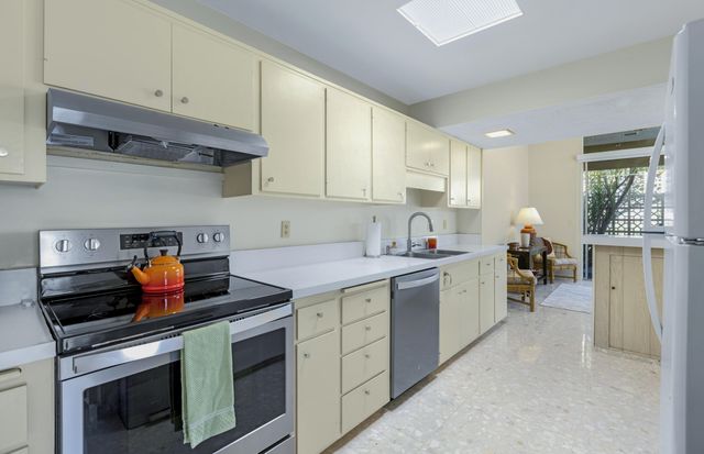 a kitchen with stainless steel appliances granite countertop a stove and cabinets