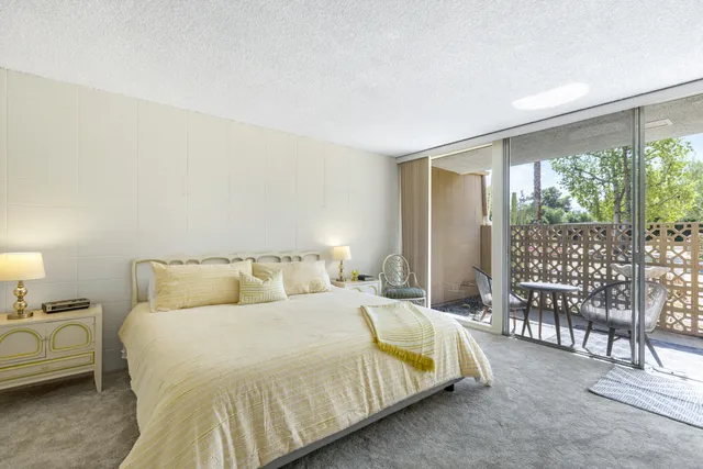 a bedroom with a bed and a large window