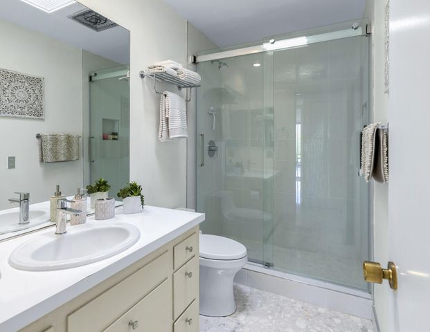 a bathroom with a sink a toilet and shower