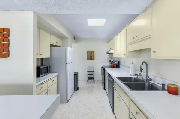 a kitchen with stainless steel appliances a sink a stove and a refrigerator