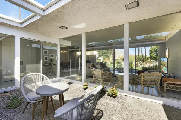 a living room with furniture and a floor to ceiling window