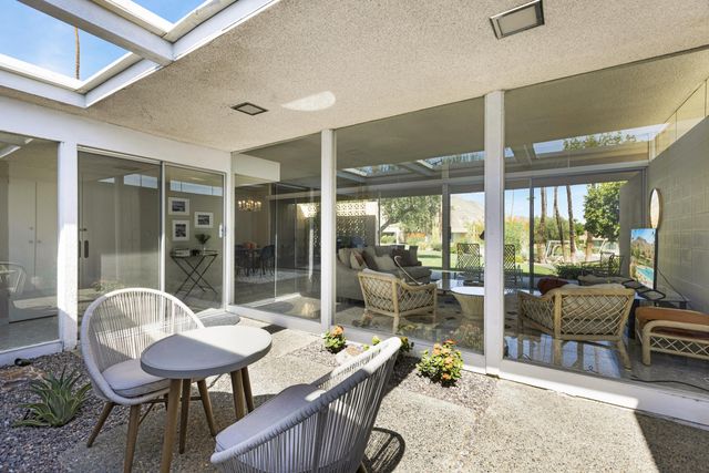 a living room with furniture and a floor to ceiling window