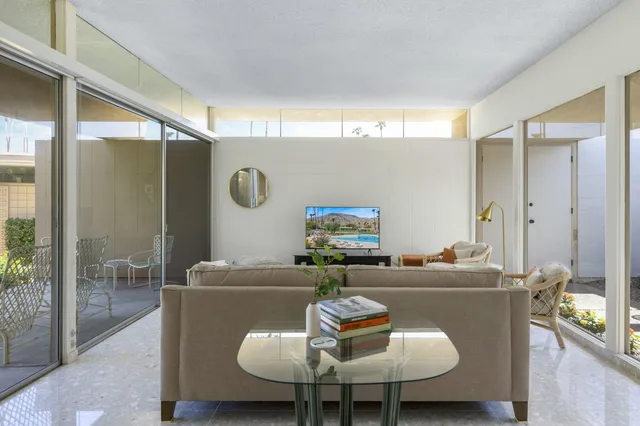a living room with furniture a window and a glass door