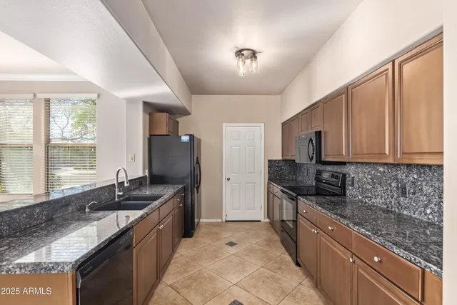 a kitchen with granite countertop a sink and a stove