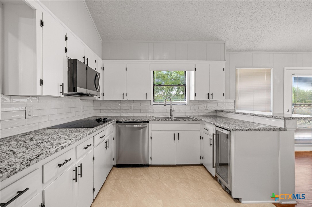 1120 Old Mill Road Salado, TX 76571 - Photo 12 of 42 a kitchen with granite countertop a sink stove and cabinets