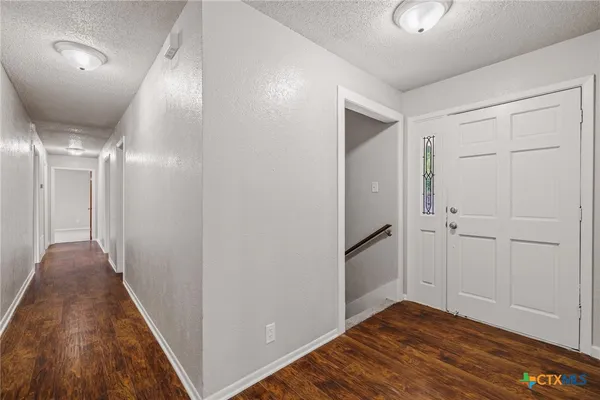 a view of a hallway with wooden floor