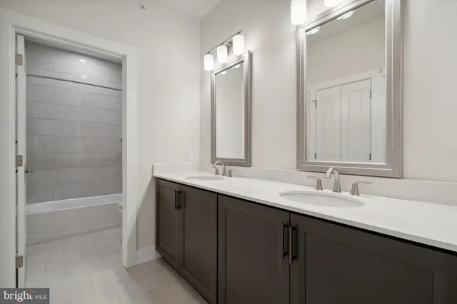a bathroom with a double vanity sink mirror double and a bathtub