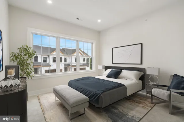 a bedroom with a bed couch and a window