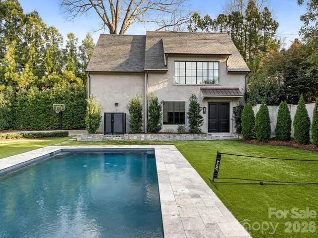 a view of a house with swimming pool and a yard in the background