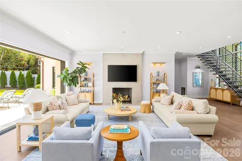 a kitchen with stainless steel appliances granite countertop a dining table chairs refrigerator a sink and a window