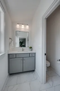 a bathroom with a toilet sink and mirror