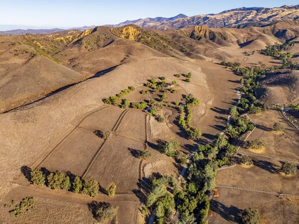 an aerial view of a house with a mountain