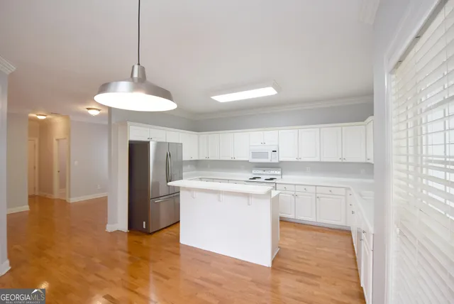 a kitchen with kitchen island a sink a counter top space stainless steel appliances and cabinets