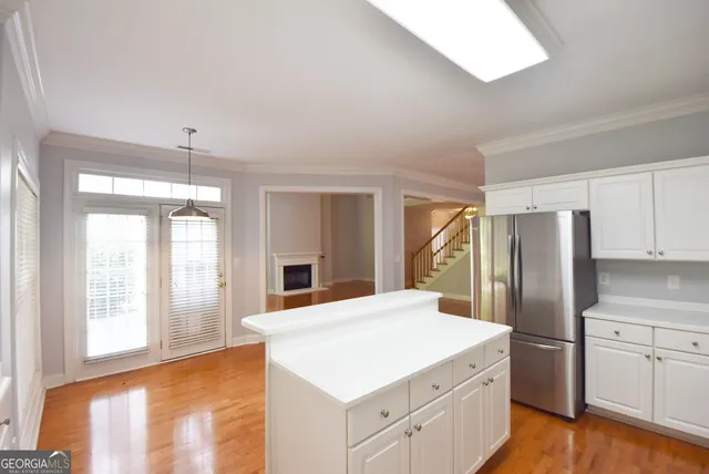 a kitchen with a refrigerator a sink and dishwasher with wooden floor