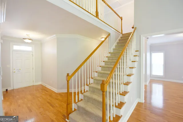 a view of a hallway with wooden floor and staircase