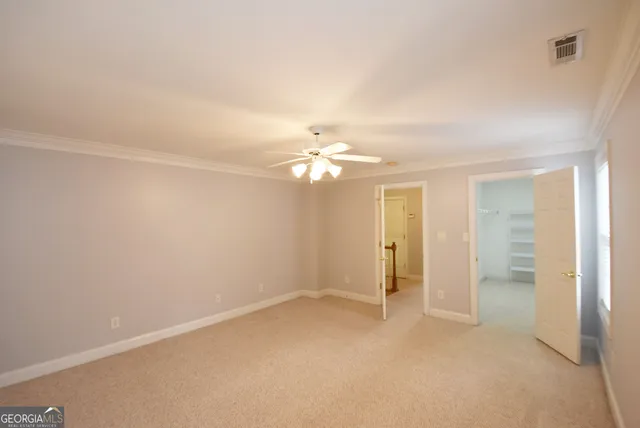 an empty room with closet and a chandelier fan