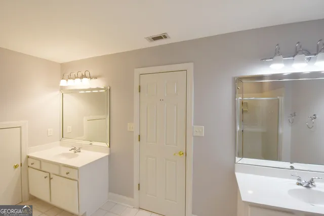 a bathroom with a sink shower and a mirror