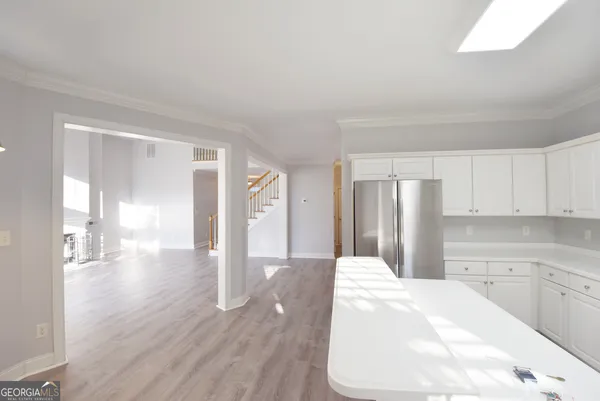 a view of a hallway with wooden floor and staircase