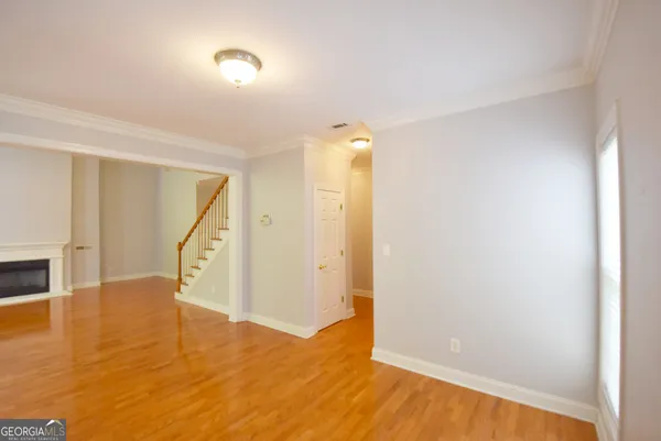 an empty room with windows and chandelier fan