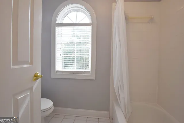 a bathroom with a toilet a sink and a window
