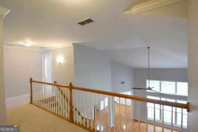 a view of staircase with railing and a chandelier