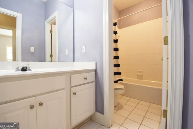 a bathroom with a granite countertop sink a toilet and shower