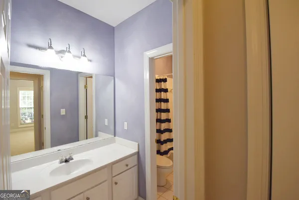 a bathroom with a granite countertop sink a toilet and shower