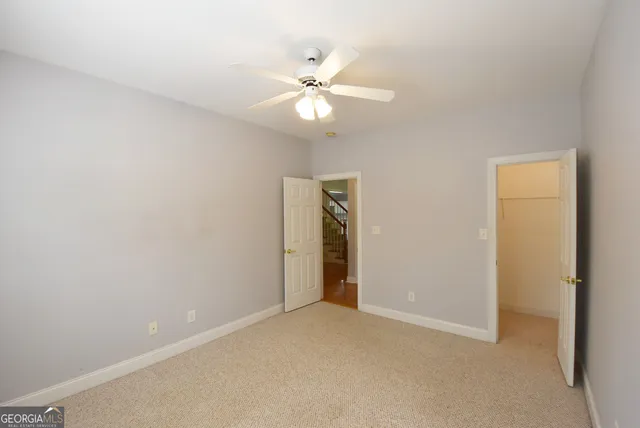 an empty room with a fan and a ceiling fan