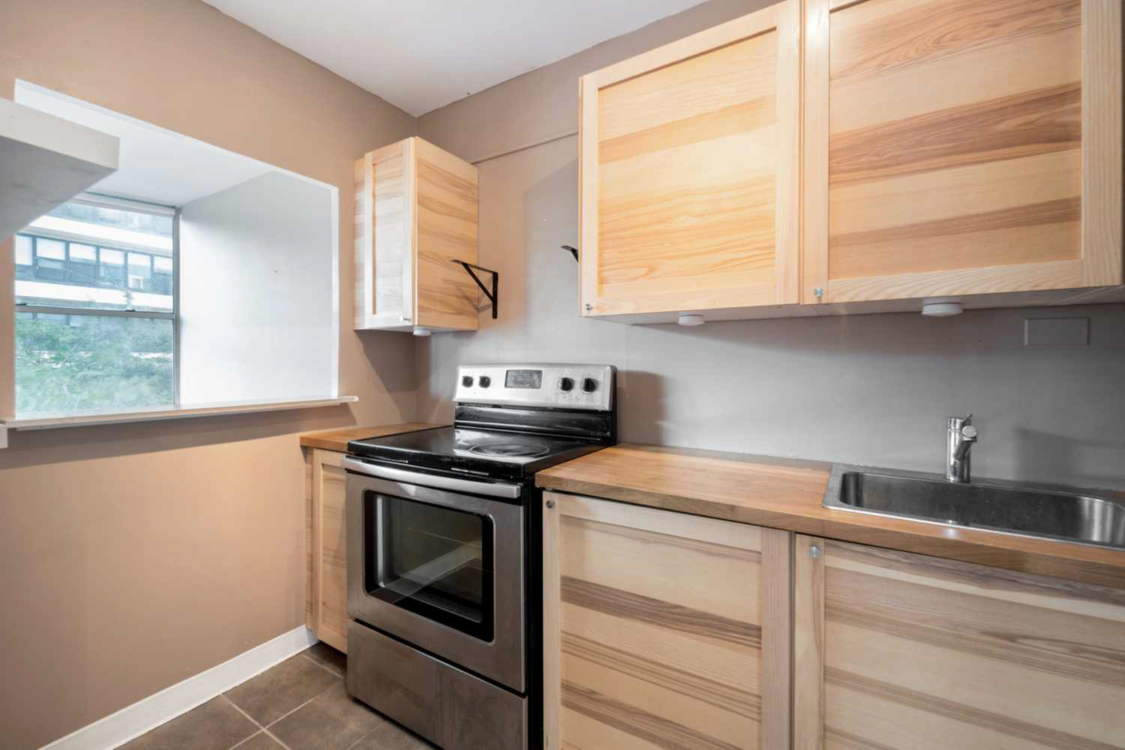 5757 North Sheridan Road, Unit 4E Chicago, IL 60660 - Photo 8 of 11 a kitchen with cabinets appliances and a window
