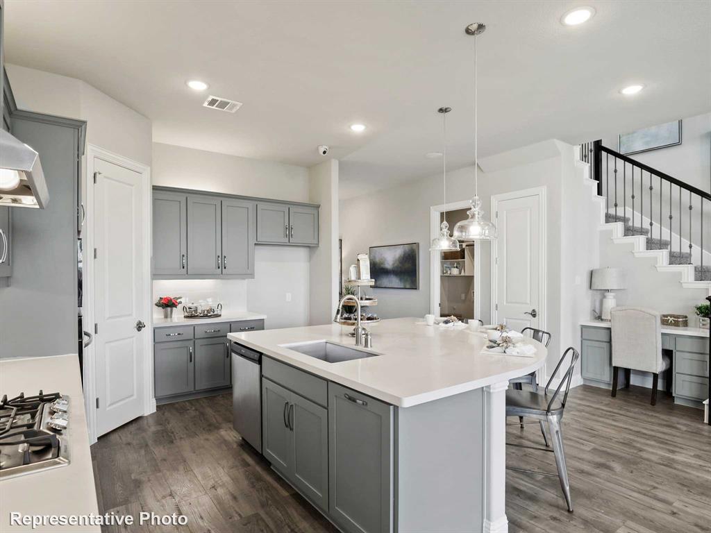 1143 Rothland Lane Red Oak, TX 75154 - Photo 5 of 18 Modern kitchen featuring an expansive island with a built-in sink and seating, gray cabinetry, white countertops, wood-finish flooring, and recessed lighting