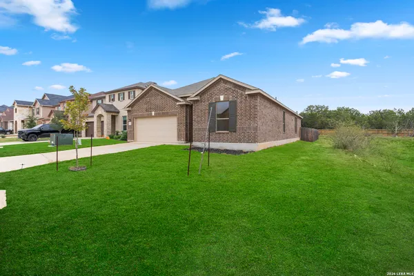 a view of a house with a big yard and large trees