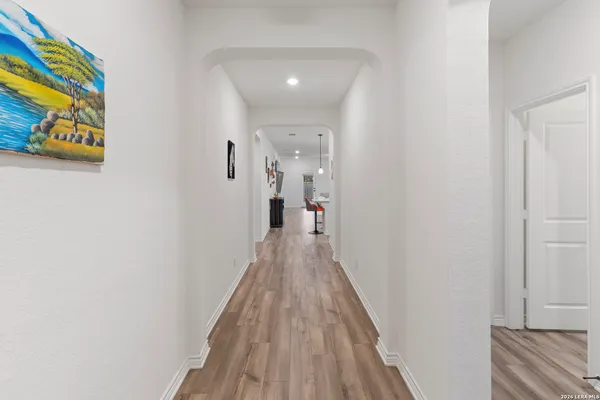 a view of a hallway with wooden floor and staircase