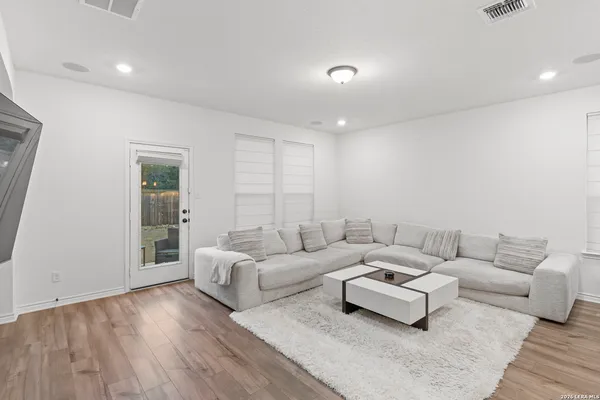 a living room with furniture and a wooden floor